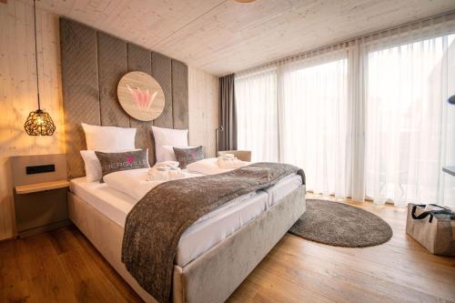 a bedroom with a large bed and a large window at Felsenland BERGVILLEN in Dahn