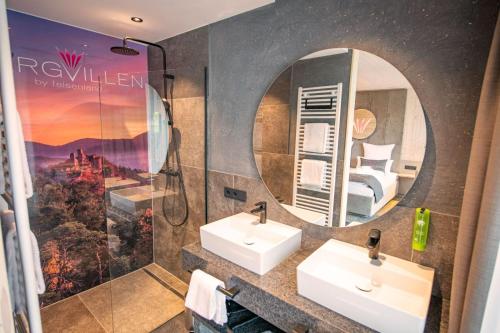 a bathroom with two sinks and a mirror at Felsenland BERGVILLEN in Dahn