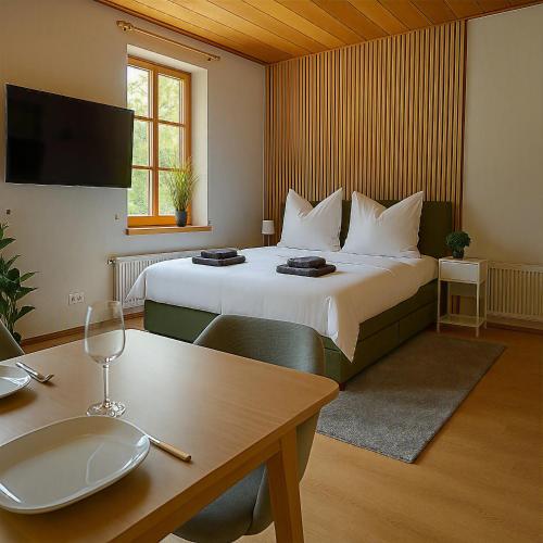 a hotel room with a large bed and a table at Direkt am Wanderweg, Ferienwohnung im Allgäu nahe Oberstaufen in Oberstaufen