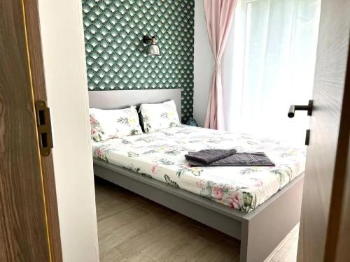a small bedroom with a bed with a green wall at Casa Roxana in Năvodari
