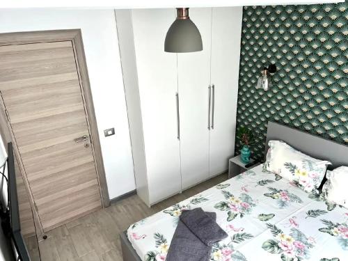 a bedroom with a bed with a floral patterned wall at Casa Roxana in Năvodari