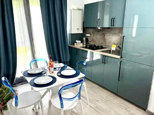 a kitchen with a table and chairs and a kitchen with blue cabinets at Casa Roxana in Năvodari