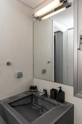 a bathroom with a sink and a large mirror at St Aims by Bluesites in Porto Heli