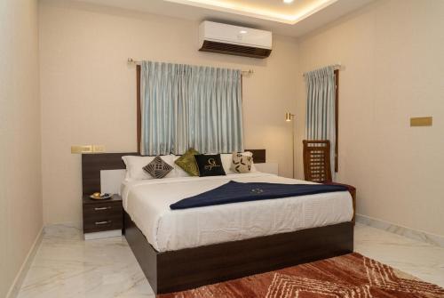 a bedroom with a bed with a blue blanket on it at The Grand Villa Kochi in Cochin