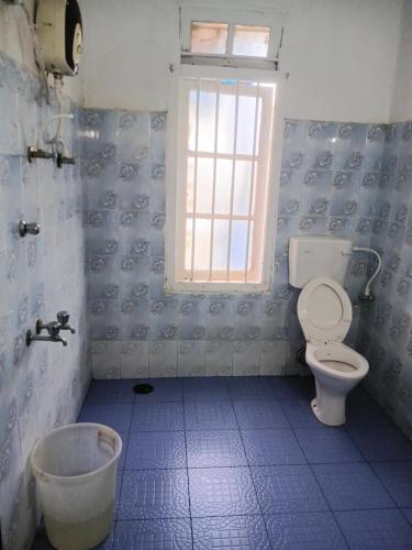 a bathroom with a toilet and a window at First Alleppey homestay in Alleppey