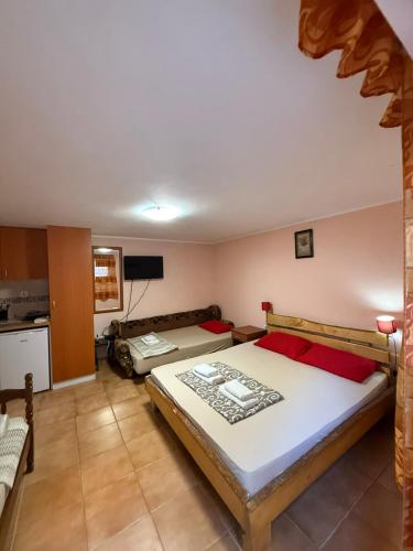 a bedroom with two beds and a kitchen at Maja Apartmani in Sutomore