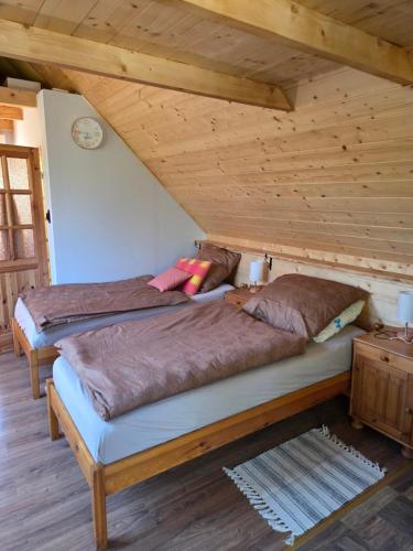 two beds in a room with wooden ceilings at Dolina Izerów in Sucha