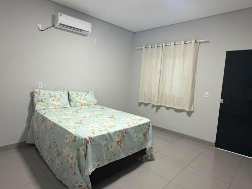 a bedroom with a bed and a air conditioner at Lotus in Gurupi
