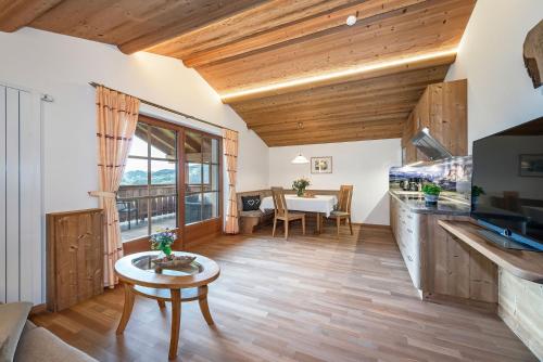 a living room with wooden ceilings and a table at Moarlhof - Farm Nature Resort in Castelrotto