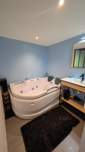 a large white bath tub in a bathroom with a sink at HOME HOSE in Monistrol-sur-Loire