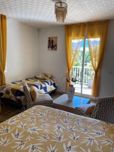 a living room with two beds and a window at Les Begonias in Cilaos