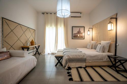 a bedroom with two beds and a large window at Villa Cactus in Ben Larbi
