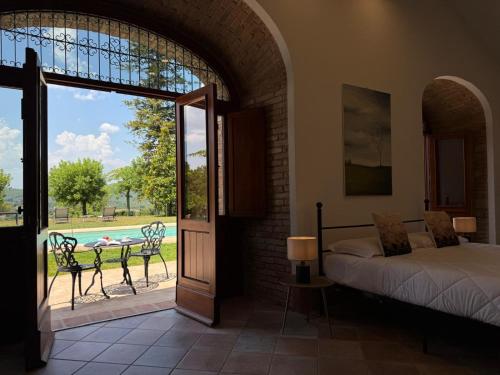 a bedroom with a bed and a view of a pool at Villa Egle Perugia in Cenerente