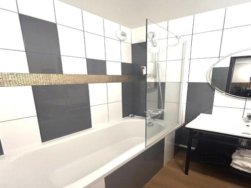 a bathroom with a tub and a sink and a mirror at Suite in Premier Thermal Spa Resort in Châtel-Guyon