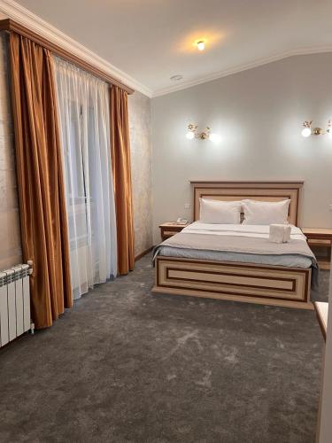 a bedroom with a bed and a large window at The House Hotel Goris in Goris