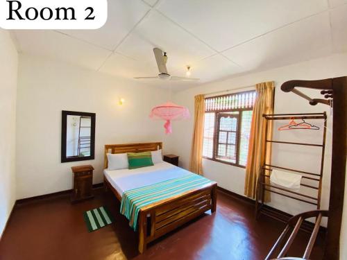 a bedroom with a bed and a window with a pink lamp at Oracle Residence in Anuradhapura