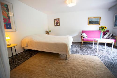 a bedroom with a bed and a pink couch at Private 2 prs basement I spacious & central CPH in Copenhagen