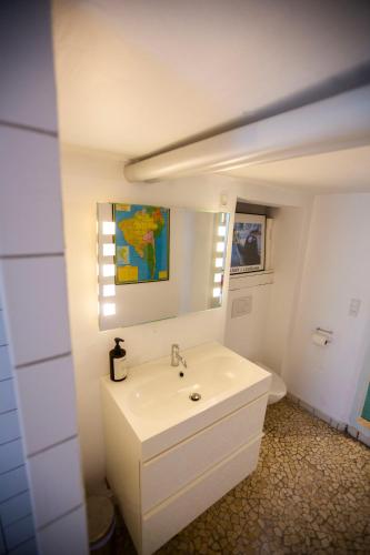 a white bathroom with a sink and a mirror at Private 2 prs basement I spacious & central CPH in Copenhagen
