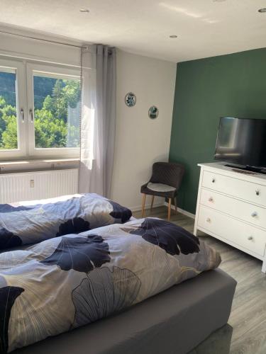 a bedroom with two beds and a flat screen tv at Ferienwohnung Weitblick in Rodalben
