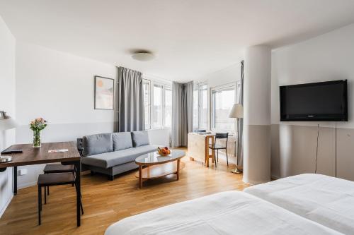 a hotel room with a bed and a living room at 2Home Hotel Apartments in Solna