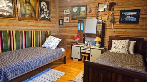 a bedroom with two beds in a log cabin at Cicha Chata in Wójtowa