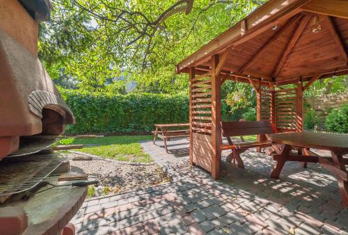 a wooden pavilion with a picnic table and a bench at Tatamka Hostel in Warsaw