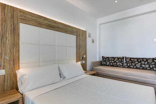 a bedroom with a bed and a bench in it at Hotel Fantasy in Riccione