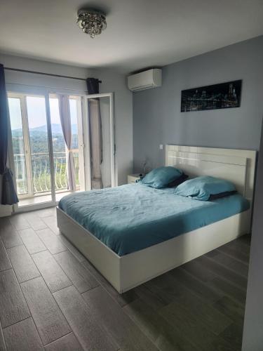 a bedroom with a bed and a large window at Chambre d hote in Le Tignet