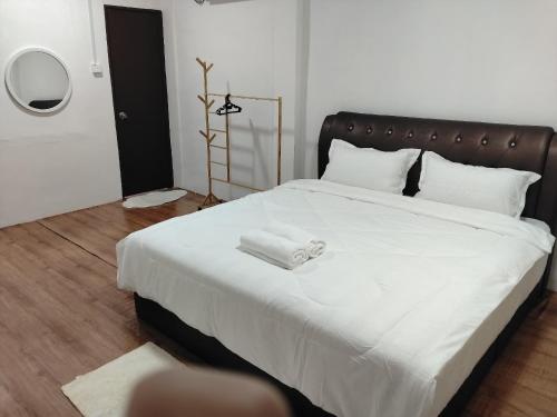a bedroom with a large white bed with white sheets at HG Homestay in Kota Kinabalu