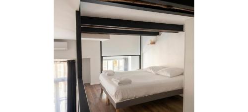 a bedroom with a bed and a large window at Doux Pavillon - Le Loft d'Or in Nice