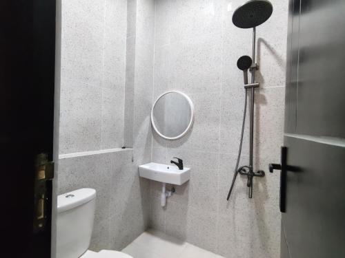 a bathroom with a toilet and a mirror and a sink at D'CIA Coliving in Kejayan