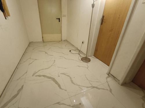 a room with a white marble floor and a door at Mountain Apartment Vlašić Babanovac in Vlasic