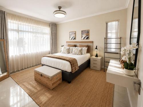 a bedroom with a bed and a large window at Moxley Manor in Durban
