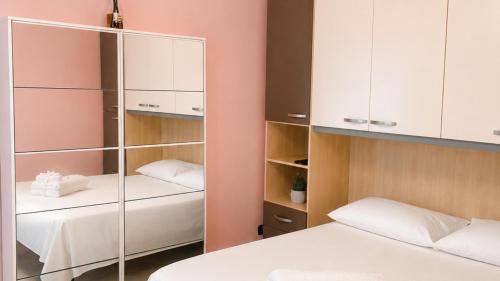ein Schlafzimmer mit zwei Betten und einem Kleiderschrank in der Unterkunft Dimora Morge in Policoro