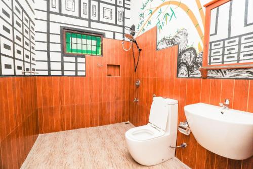 a bathroom with a toilet and a sink at Shena resort in Habarana