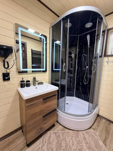 a bathroom with a shower with a sink and a mirror at Подих Свободи in Sloboda
