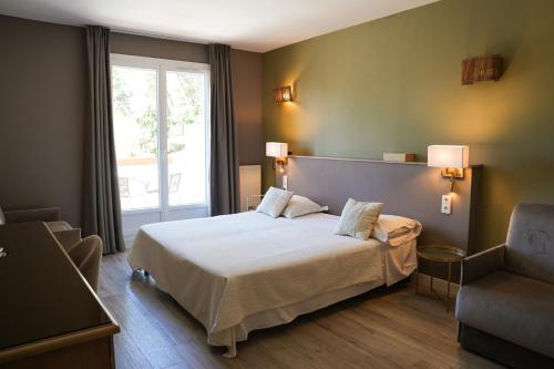 a bedroom with a large bed and a window at Domaine de l'Oustalia in Aix-en-Provence