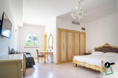 a bedroom with a bed and a desk in a room at Hotiday San Felice Circeo in San Felice Circeo