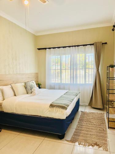 a bedroom with a large bed with a window at No 80 At Erasmus in Polokwane