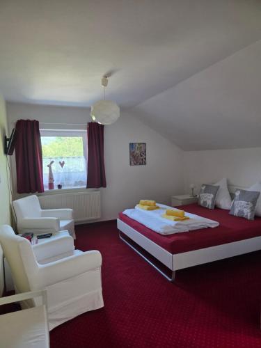 a bedroom with a bed and two white chairs at Pension Eva in Domažlice