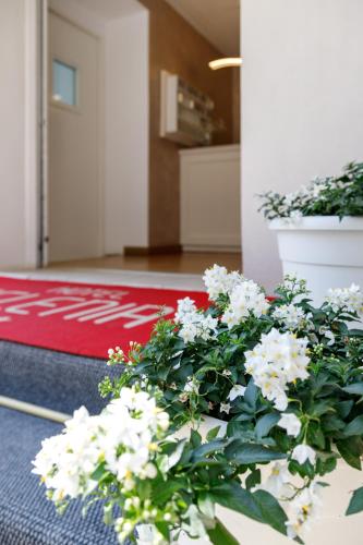 a living room with white flowers and a red rug at Hotel Telenia in Lido di Jesolo