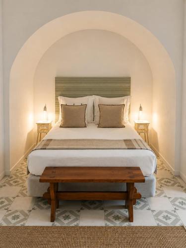 a bedroom with a large bed and two lamps at CASA d’OLIVENÇA in Elvas