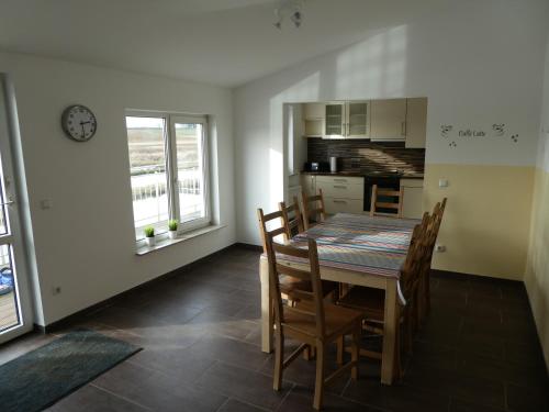 a kitchen and dining room with a table and chairs at Ruhige Ferienwohnungen mit Teichblick in Wetterfeld