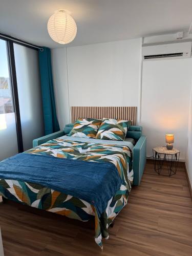 a bedroom with a blue bed with a blue blanket at Coeur SAINT-PAUL in Saint-Paul