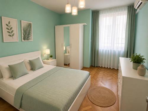 a bedroom with a large bed with blue walls at Catherdral Apartments with Parking in Varna City