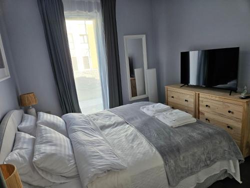 a bedroom with a bed and a flat screen tv at Wypoczynek nad morzem Uzdrowiskowa 115 in Przewłoka