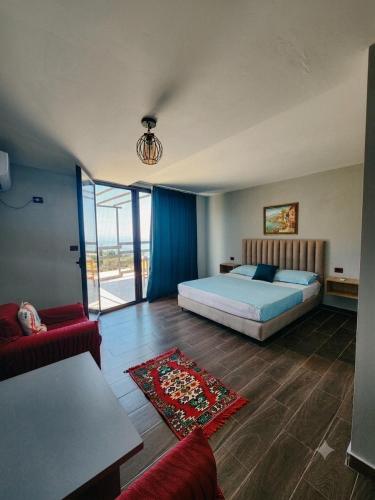 a bedroom with a bed and a living room at Vila zaho in Dhërmi