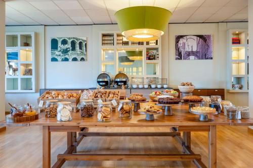 a table with many different types of food on it at B&B HOTEL Expo Verona Villafranca in Villafranca di Verona