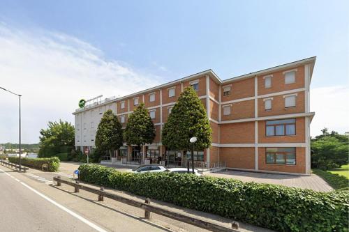 a building with a car parked in front of it at B&B HOTEL Mantova Cristallo in Virgilio