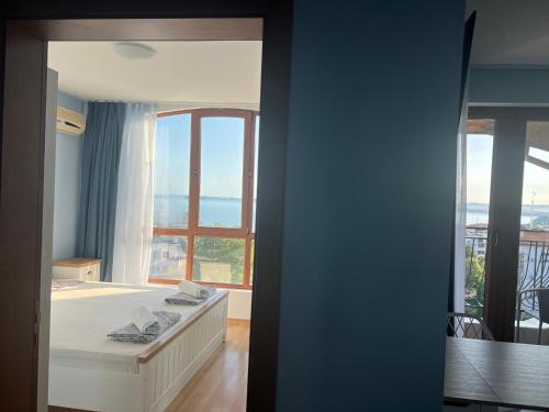 a bedroom with a bed and a large window at Triumph Fantastic View in Sveti Vlas